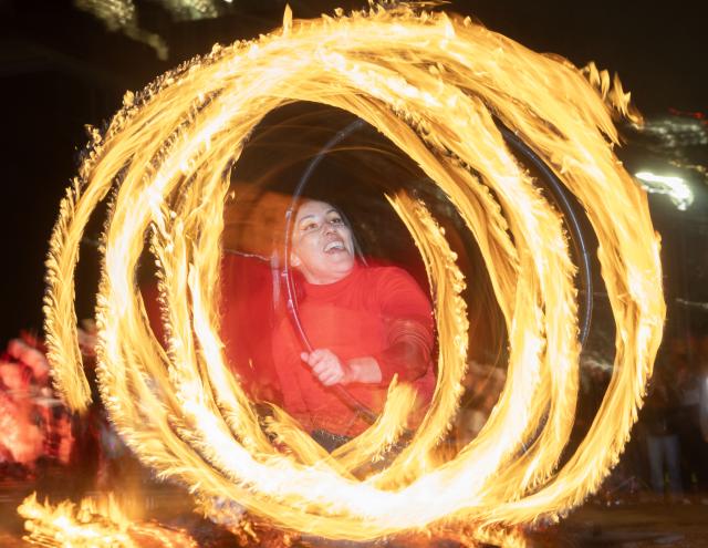 (251222) -- TORONTO, Dec. 22, 2025 (Xinhua) -- A woman performs with fire at the 2025 Kensington Market Winter Solstice event in Toronto, Canada, Dec. 21, 2025. The annual event to celebrate the longest night of the year was held here on Sunday. (Photo by Zou Zheng/Xinhua)
