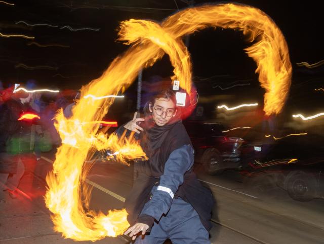 (251222) -- TORONTO, Dec. 22, 2025 (Xinhua) -- A man performs with fire at the 2025 Kensington Market Winter Solstice event in Toronto, Canada, Dec. 21, 2025. The annual event to celebrate the longest night of the year was held here on Sunday. (Photo by Zou Zheng/Xinhua)