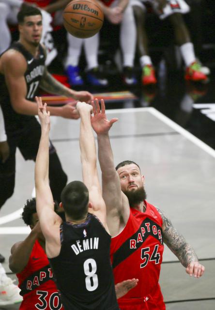 (251222) -- NEW YORK, Dec. 22, 2025 (Xinhua) -- Egor Demin (front) of Brooklyn Nets shoots under the defence of Sandro Mamukelashvili (R) of Toronto Raptors during the 2025-2026 NBA regular season game between Brooklyn Nets and Toronto Raptors in New York, the United States, Dec. 21, 2025. (Xinhua/Zhang Fengguo)
