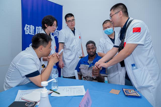 (251222) -- MAPUTO, Dec. 22, 2025 (Xinhua) -- Members of the 26th Chinese medical team to Mozambique check on a man during a free medical outreach in Maputo, Mozambique, Dec. 20, 2025. The 26th Chinese medical team conducted a free health outreach on Saturday for workers at an industrial company in Maputo, Mozambique's capital, providing on-site medical examinations that were widely praised by employees and company management. (Photo by Mendes Mondlane/Xinhua)