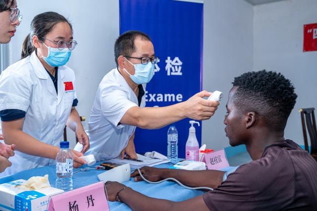 (251222) -- MAPUTO, Dec. 22, 2025 (Xinhua) -- Members of the 26th Chinese medical team to Mozambique check on a man during a free medical outreach in Maputo, Mozambique, Dec. 20, 2025. The 26th Chinese medical team conducted a free health outreach on Saturday for workers at an industrial company in Maputo, Mozambique's capital, providing on-site medical examinations that were widely praised by employees and company management. (Photo by Mendes Mondlane/Xinhua)