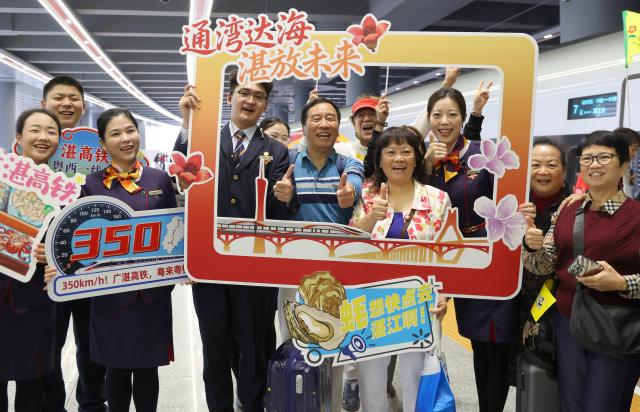 (251222) -- GUANGZHOU, Dec. 22, 2025 (Xinhua) -- Passengers about to board the first train of the Guangzhou-Zhanjiang High-Speed Railway pose for a group photo with railway crew members at the Guangzhou Baiyun Railway Station in Guangzhou, south China's Guangdong Province, Dec. 22, 2025.
  Spanning approximately 401 kilometers, the Guangzhou-Zhanjiang High-Speed Railway began operation on Monday. With a designed top speed of 350 kilometers per hour, the travel time can be reduced to around one hour and a half between the Guangzhou Baiyun Railway Station and the Zhanjiang North Railway Station, both in Guangdong. (Xinhua/Lu Hanxin)
