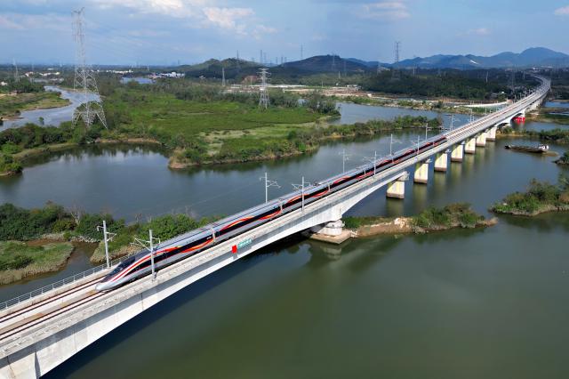 (251222) -- GUANGZHOU, Dec. 22, 2025 (Xinhua) -- A bullet train runs on a bridge along the Guangzhou-Zhanjiang High-Speed Railway in south China's Guangdong Province, Dec. 22, 2025.
  Spanning approximately 401 kilometers, the Guangzhou-Zhanjiang High-Speed Railway began operation on Monday. With a designed top speed of 350 kilometers per hour, the travel time can be reduced to around one hour and a half between the Guangzhou Baiyun Railway Station and the Zhanjiang North Railway Station, both in Guangdong. (Photo by Wei Jie/Xinhua)