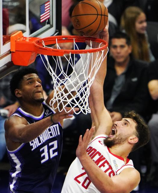 (251222) -- SACRAMENTO, Dec. 22, 2025 (Xinhua) -- Alperen Sengun (R) of Houston Rockets dunks during the 2025-2026 NBA regular season match between Houston Rockets and Sacramento Kings in Sacramento, the United States, on Dec. 21, 2025. (Xinhua/Wu Xiaoling)