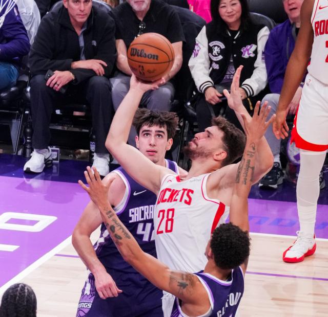 (251222) -- SACRAMENTO, Dec. 22, 2025 (Xinhua) -- Alperen Sengun (top R) of Houston Rockets goes for a layup during the 2025-2026 NBA regular season match between Houston Rockets and Sacramento Kings in Sacramento, the United States, on Dec. 21, 2025. (Photo by Sun Yuxuan/Xinhua)