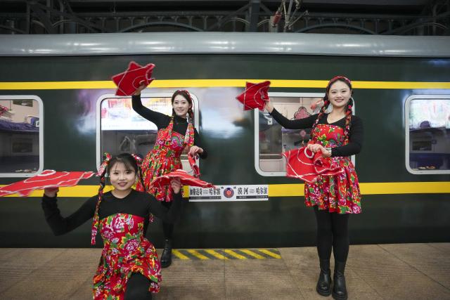 (251222) -- HARBIN, Dec. 22, 2025 (Xinhua) -- Actresses stage a folk performance for passengers on the platform at Harbin Railway Station in Harbin, northeast China's Heilongjiang Province, on Dec. 22, 2025. Train K7041, the first northeast folk culture-themed train operated this winter, departed from Harbin Railway Station and headed for Mohe City on Monday. (Xinhua/Wang Song)