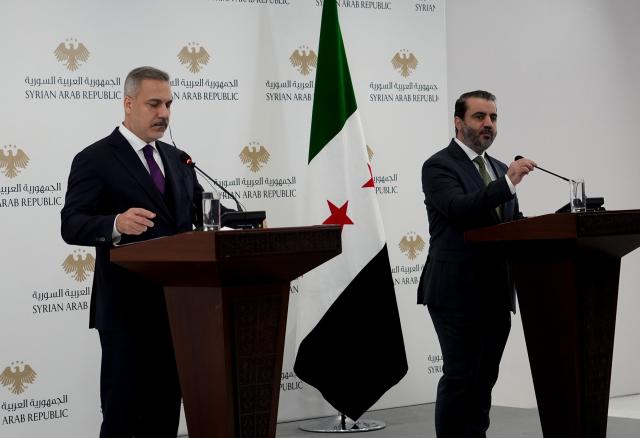 (251222) -- DAMASCUS, Dec. 22, 2025 (Xinhua) -- Syrian Foreign Minister Asaad Hassan al-Shibani (R) and Turkish Foreign Minister Hakan Fidan attend a joint press conference in Damascus, Syria, Dec. 22, 2025. Al-Shibani and Fidan met here on Monday to discuss refugee returns, economic cooperation and regional security. TO GO WITH "Syrian, Turkish FMs discuss refugees, economy and security in Damascus" (Photo by Ammar Safarjalani/Xinhua)