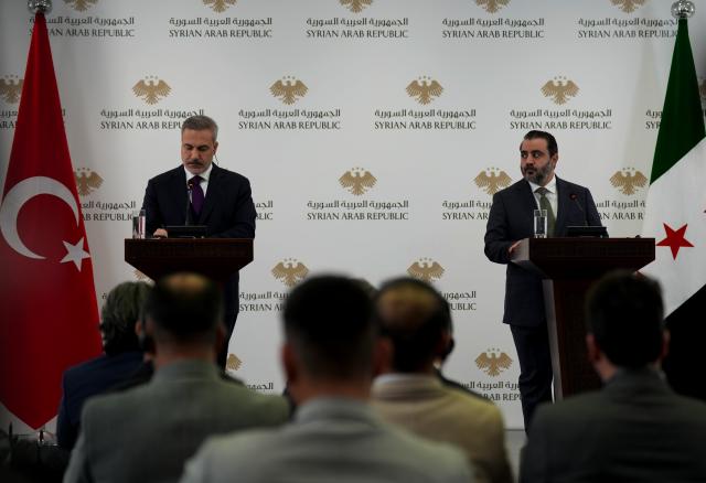 (251222) -- DAMASCUS, Dec. 22, 2025 (Xinhua) -- Syrian Foreign Minister Asaad Hassan al-Shibani (R) and Turkish Foreign Minister Hakan Fidan attend a joint press conference in Damascus, Syria, Dec. 22, 2025. Al-Shibani and Fidan met here on Monday to discuss refugee returns, economic cooperation and regional security. TO GO WITH "Syrian, Turkish FMs discuss refugees, economy and security in Damascus" (Photo by Ammar Safarjalani/Xinhua)