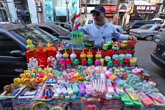 (251222) -- TRIPOLI, Dec. 22, 2025 (Xinhua) -- A vendor prepares his merchandise for Christmas in Tripoli, northern Lebanon, on Dec. 22, 2025. (Photo by Bilal Jawich/Xinhua)
