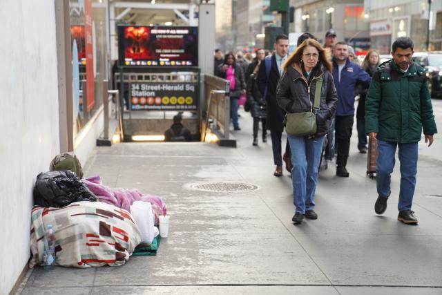 (251222) -- NEW YORK, Dec. 22, 2025 (Xinhua) -- A homeless man sleeps on a street in New York City, the United States, on Dec. 18, 2025. (Xinhua/Zhang Fengguo)