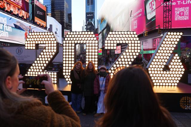 (251223) -- NEW YORK, Dec. 23, 2025 (Xinhua) -- People pose for photos in front of a light installation for the upcoming 2026 at Times Square in New York, the United States, Dec. 22, 2025. (Xinhua/Zhang Fengguo)