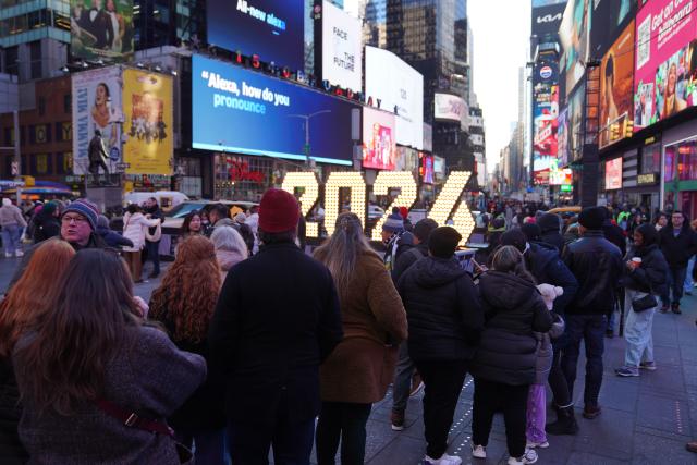 (251223) -- NEW YORK, Dec. 23, 2025 (Xinhua) -- People line up to take photos with a light installation for the upcoming 2026 at Times Square in New York, the United States, Dec. 22, 2025. (Xinhua/Zhang Fengguo)