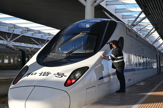 (251223) -- BAOTOU, Dec. 23, 2025 (Xinhua) -- A staff member checks the first train of the Baotou-Yinchuan High-Speed Railway at Baotou Railway Station in Baotou, north China's Inner Mongolia Autonomous Region, Dec. 23, 2025. The Baotou-Huinong section of the Baotou-Yinchuan High-Speed Railway was completed and opened to traffic on Tuesday, marking the full-line operation of the railway. (Xinhua/Li Zhipeng)