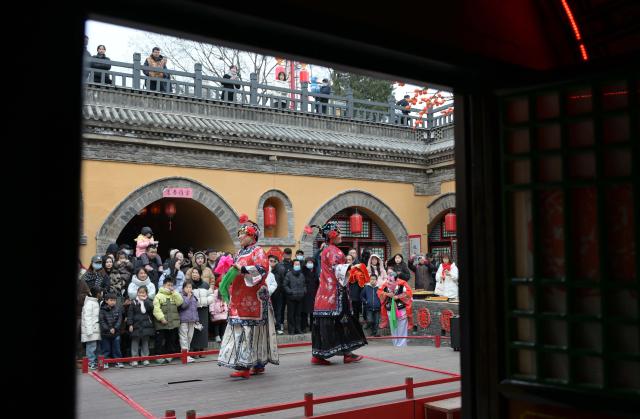 (251223) -- BEIJING, Dec. 23, 2025 (Xinhua) -- Tourists watch a folk performance at a traditional Dikengyuan residence in Beiying Village, Zhangbian Township, Shanzhou District, Sanmenxia City of central China's Henan Province, Dec. 21, 2025.
  The Dikengyuan residence, a traditional residential construction in west Henan featuring a sunken courtyard, is of high value in the study of local history, architecture, geology and sociology. (Photo by Miao Yucai/Xinhua)