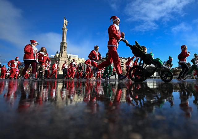 (251223) -- BEIJING, Dec. 23, 2025 (Xinhua) -- Runners in Santa Claus costumes attend a Christmas-themed running event in Madrid, Spain, Dec. 21, 2025. (Xinhua/Cheng Min)