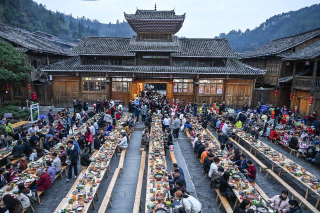 (251223) -- LIPING, Dec. 23, 2025 (Xinhua) -- This photo shows a long-table banquet joined by tourists and locals in Zhaoxing Dong village of Liping County, southwest China's Guizhou Province, Dec. 20, 2025.
  Zhaoxing Dong village, home to a captivating cultural landscape, has seen an influx of tourists as the Dong New Year approaches.
  In recent years, the local government has leveraged the village's rich Dong ethnic cultural resources in developing the tourism industry.
  Boosted by tourism and other feature industries, the local Dong people have improved their living standards by inheriting traditional craftsmanship, developing ethnic handicrafts, launching cultural and creative products, and expanding the homestay and catering businesses. (Xinhua/Yang Wenbin)