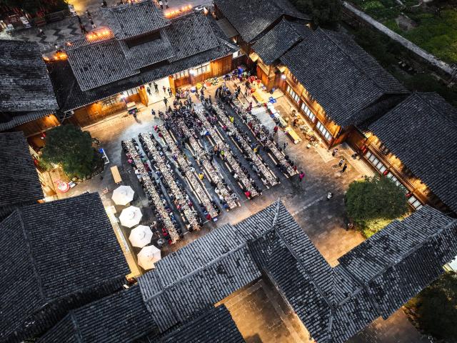 (251223) -- LIPING, Dec. 23, 2025 (Xinhua) -- An aerial drone photo shows a long-table banquet joined by tourists and locals in Zhaoxing Dong village of Liping County, southwest China's Guizhou Province, Dec. 20, 2025.
  Zhaoxing Dong village, home to a captivating cultural landscape, has seen an influx of tourists as the Dong New Year approaches.
  In recent years, the local government has leveraged the village's rich Dong ethnic cultural resources in developing the tourism industry.
  Boosted by tourism and other feature industries, the local Dong people have improved their living standards by inheriting traditional craftsmanship, developing ethnic handicrafts, launching cultural and creative products, and expanding the homestay and catering businesses. (Xinhua/Yang Wenbin)