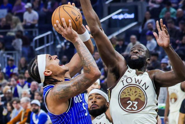 (251223) -- SAN FRANCISCO, Dec. 23, 2025 (Xinhua) -- Draymond Green (R) of Golden State Warriors vies with Paolo Banchero of Orlando Magic during the 2025-2026 NBA regular season game between Golden State Warriors and Orlando Magic in San Francisco, the United States, Dec. 22, 2025. (Photo by Arthur Dong/Xinhua)