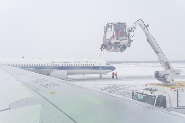 (251223) -- HARBIN, Dec. 23, 2025 (Xinhua) -- Staff members conduct de-icing and snow removal operations on an aircraft at Harbin Taiping International Airport in Harbin, northeast China's Heilongjiang Province, Dec. 23, 2025. The meteorological observatory of Harbin issued a yellow alert for blizzard on Tuesday. (Xinhua/Xie Jianfei)