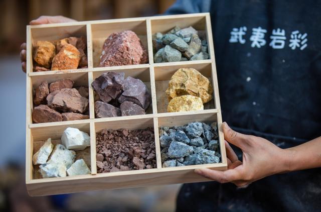 (251223) -- WUYISHAN, Dec. 23, 2025 (Xinhua) -- An artist displays the rock pigment materials in Wuyishan City, southeast China's Fujian Province, Dec. 22, 2025. Wuyishan boasts a wide range of colorful rock and soil, which serve as a natural palette for painting, giving rise to the distinctive Wuyi rock pigment art. Integrating modern artistic elements and techniques into tradition, Wuyi rock pigment painting is gradually becoming a unique cultural feature of Wuyishan. (Photo by Chen Ying/Xinhua)