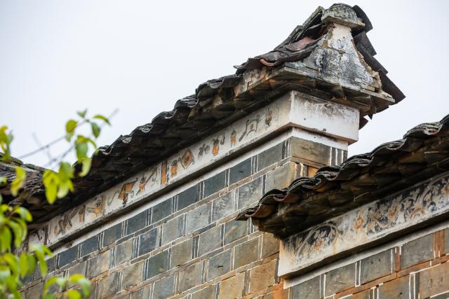 (251223) -- WUYISHAN, Dec. 23, 2025 (Xinhua) -- This photo taken on Dec. 21, 2025 shows decorative patterns painted with rock pigments on an ancient residential building in Wuyishan City, southeast China's Fujian Province. Wuyishan boasts a wide range of colorful rock and soil, which serve as a natural palette for painting, giving rise to the distinctive Wuyi rock pigment art. Integrating modern artistic elements and techniques into tradition, Wuyi rock pigment painting is gradually becoming a unique cultural feature of Wuyishan. (Photo by Chen Ying/Xinhua)