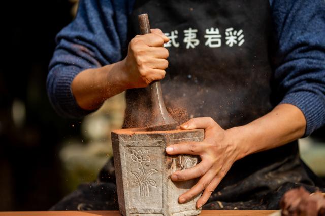 (251223) -- WUYISHAN, Dec. 23, 2025 (Xinhua) -- An artist grinds rock and soil into powder in Wuyishan City, southeast China's Fujian Province, Dec. 19, 2025. Wuyishan boasts a wide range of colorful rock and soil, which serve as a natural palette for painting, giving rise to the distinctive Wuyi rock pigment art. Integrating modern artistic elements and techniques into tradition, Wuyi rock pigment painting is gradually becoming a unique cultural feature of Wuyishan. (Photo by Chen Ying/Xinhua)