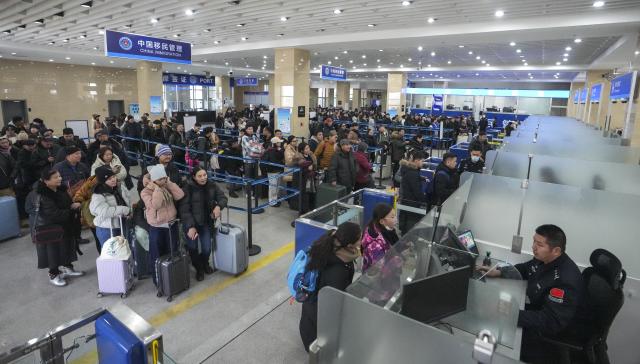 (251223) -- ERENHOT, Dec. 23, 2025 (Xinhua) -- Passengers go through border inspection procedures at a land port in Erenhot, north China's Inner Mongolia Autonomous Region, Dec. 22, 2025. Erenhot, the largest land port on the China-Mongolia border, is a pivotal point of the China-Mongolia-Russia Economic Corridor. As of Dec. 22, inbound and outbound passenger traffic volumes and the number of vehicles driving through Erenhot reached 2.753 million and 741,000, respectively, up by 8.8 percent and 12.1 percent compared with the same period of last year. (Photo by Guo Pengjie/Xinhua)