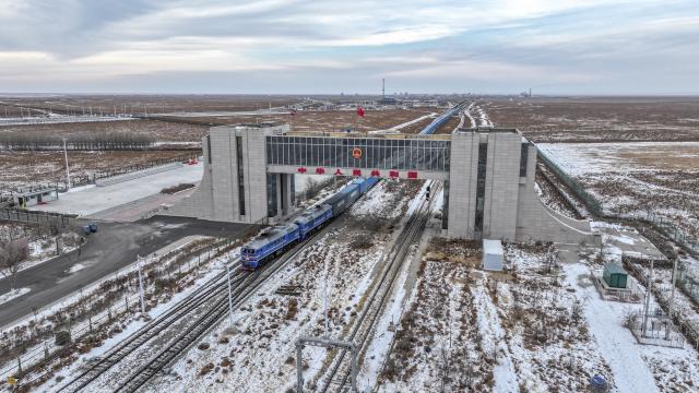 (251223) -- ERENHOT, Dec. 23, 2025 (Xinhua) -- An aerial drone photo taken on Dec. 22, 2025 shows an inbound China-Europe freight train passes through a land port in Erenhot, north China's Inner Mongolia Autonomous Region. Erenhot, the largest land port on the China-Mongolia border, is a pivotal point of the China-Mongolia-Russia Economic Corridor. As of Dec. 22, inbound and outbound passenger traffic volumes and the number of vehicles driving through Erenhot reached 2.753 million and 741,000, respectively, up by 8.8 percent and 12.1 percent compared with the same period of last year. (Xinhua/Ma Jinrui)