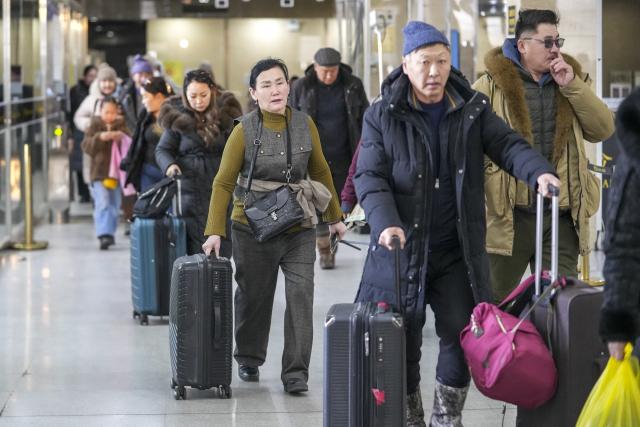 (251223) -- ERENHOT, Dec. 23, 2025 (Xinhua) -- Passengers prepare to go through border inspection procedures at a land port in Erenhot, north China's Inner Mongolia Autonomous Region, Dec. 22, 2025. Erenhot, the largest land port on the China-Mongolia border, is a pivotal point of the China-Mongolia-Russia Economic Corridor. As of Dec. 22, inbound and outbound passenger traffic volumes and the number of vehicles driving through Erenhot reached 2.753 million and 741,000, respectively, up by 8.8 percent and 12.1 percent compared with the same period of last year. (Photo by Guo Pengjie/Xinhua)