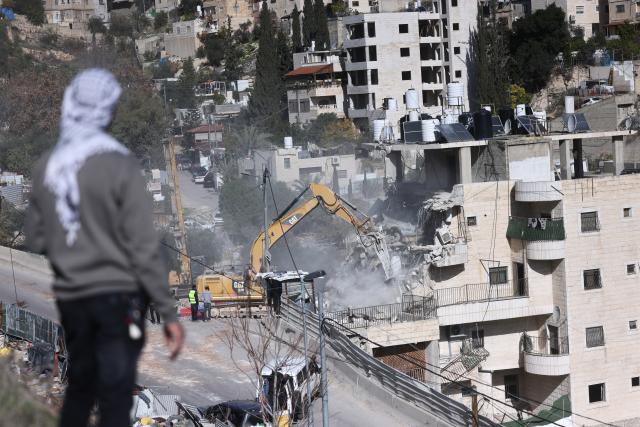 (251223) -- JERUSALEM, Dec. 23, 2025 (Xinhua) -- A Palestinian man watches as Israeli forces demolish a residential building in the Silwan neighborhood of east Jerusalem, on Dec. 22, 2025. Israeli forces on Monday demolished a four-floor residential building in Silwan, a Palestinian neighborhood in east Jerusalem. The apartment building, home to about 90 Palestinian residents living in 13 residential units, was the largest residential structure demolished in the area this year, according to Israeli rights group Ir Amim. (Photo by Jamal Awad/Xinhua)