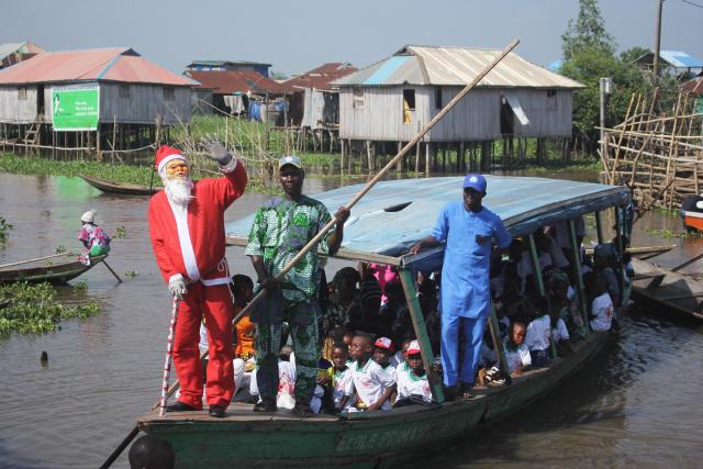 (251223) -- GANVIE (BENIN), Dec. 23, 2025 (Xinhua) -- Children take part in a Christmas-themed event held in Ganvie water village, near Cotonou, Benin, Dec. 23, 2025. (Photo by Seraphin Zounyekpe/Xinhua)