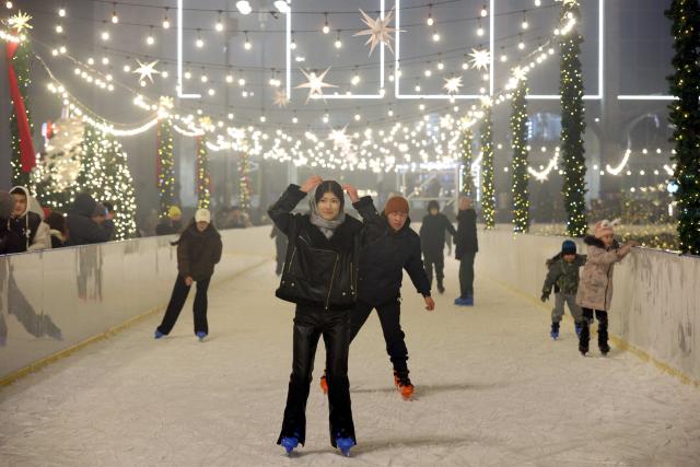 (251224) -- BISHKEK, Dec. 24, 2025 (Xinhua) -- People skate at the Ala-Too Square during a New Year event in Bishkek, Kyrgyzstan, Dec. 23, 2025. (Photo by Roman/Xinhua)