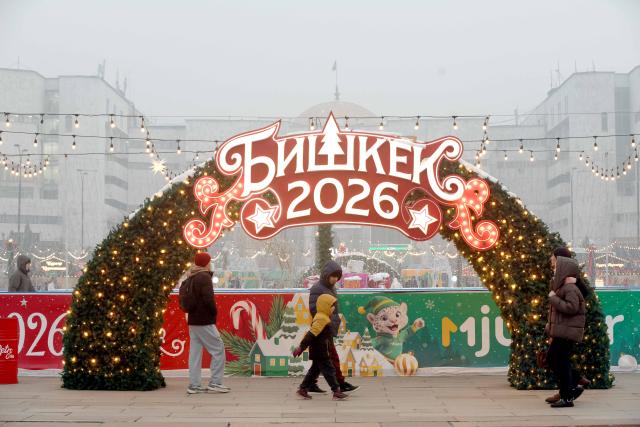 (251224) -- BISHKEK, Dec. 24, 2025 (Xinhua) -- People walk past New Year decorations at the Ala-Too Square in Bishkek, Kyrgyzstan, Dec. 23, 2025. (Photo by Roman/Xinhua)