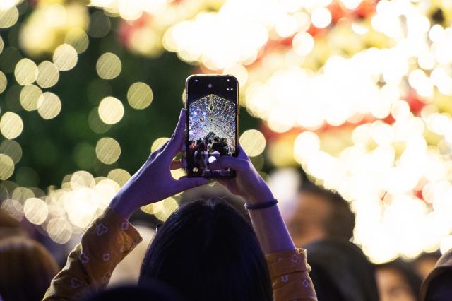 (251224) -- JAKARTA, Dec. 24, 2025 (Xinhua) -- A woman takes photos during the Jakarta Light Festival in Jakarta, Indonesia, Dec. 23, 2025. (Xinhua/Veri Sanovri)