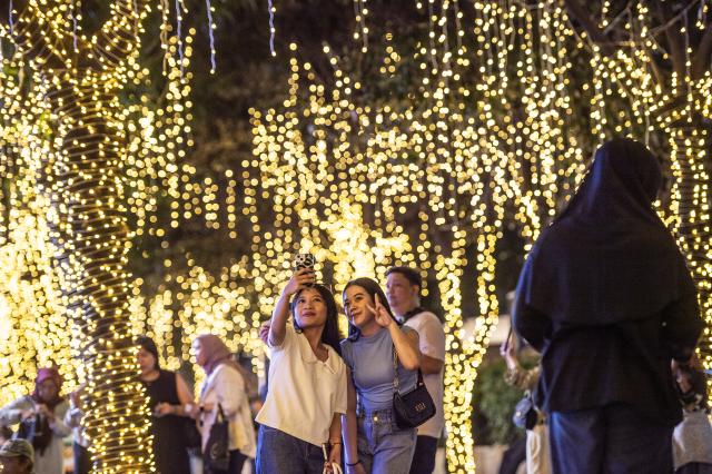 (251224) -- JAKARTA, Dec. 24, 2025 (Xinhua) -- People visit the Jakarta Light Festival in Jakarta, Indonesia, Dec. 23, 2025. (Xinhua/Veri Sanovri)