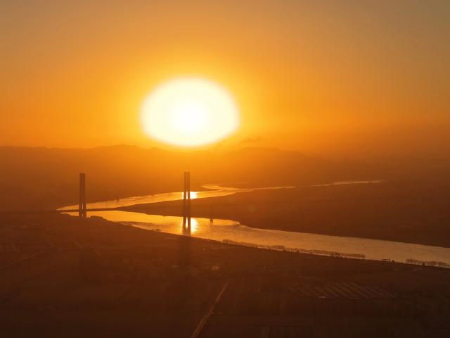 (251224) -- BEIJING, Dec. 24, 2025 (Xinhua) -- This photo taken on Dec. 23, 2025 shows a sunrise over a grand bridge across Yellow River in the Wuhai section of the Baotou-Yinchuan High-Speed Railway in Wuhai City, north China's Inner Mongolia Autonomous Region. (Xinhua/Xing Guangli)