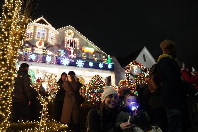 (251224) -- NEW YORK, Dec. 24, 2025 (Xinhua) -- People are seen in front of holiday light decorations at Dyker Heights of Brooklyn in New York, the United States, Dec. 23, 2025. Residents of Dyker Heights in New York City decorated their houses with colorful lights to celebrate Christmas Day and the New Year, making their community an attraction during the holiday season. (Xinhua/Zhang Fengguo)