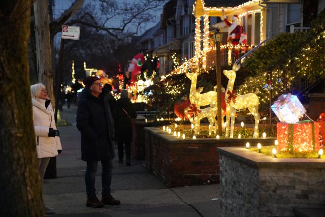 (251224) -- NEW YORK, Dec. 24, 2025 (Xinhua) -- People view holiday light decorations at Dyker Heights of Brooklyn in New York, the United States, Dec. 23, 2025. Residents of Dyker Heights in New York City decorated their houses with colorful lights to celebrate Christmas Day and the New Year, making their community an attraction during the holiday season. (Xinhua/Zhang Fengguo)