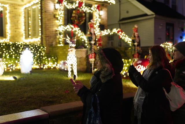(251224) -- NEW YORK, Dec. 24, 2025 (Xinhua) -- People view holiday light decorations at Dyker Heights of Brooklyn in New York, the United States, Dec. 23, 2025. Residents of Dyker Heights in New York City decorated their houses with colorful lights to celebrate Christmas Day and the New Year, making their community an attraction during the holiday season. (Xinhua/Zhang Fengguo)