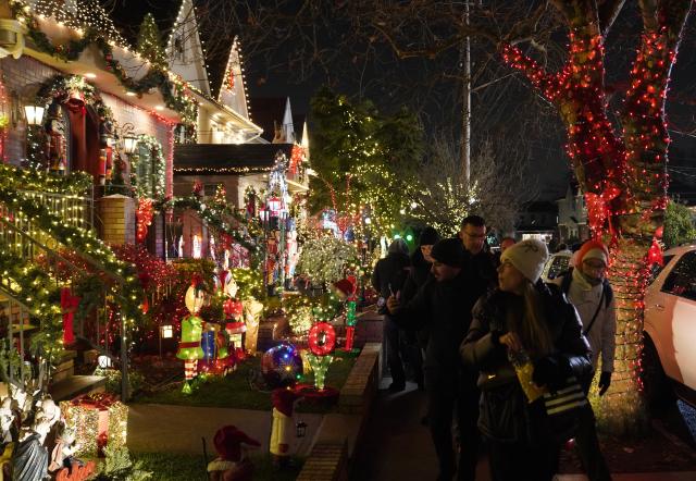 (251224) -- NEW YORK, Dec. 24, 2025 (Xinhua) -- People view holiday light decorations at Dyker Heights of Brooklyn in New York, the United States, Dec. 23, 2025. Residents of Dyker Heights in New York City decorated their houses with colorful lights to celebrate Christmas Day and the New Year, making their community an attraction during the holiday season. (Xinhua/Zhang Fengguo)