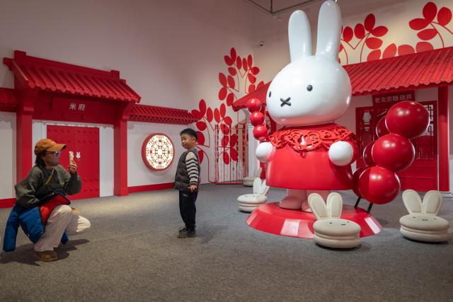 (251224) -- BEIJING, Dec. 24, 2025 (Xinhua) -- People take photos while visiting the exhibition "Miffy and Friends China Experience" at the Times Art Museum in Beijing, capital of China, Dec. 24, 2025. Miffy is a world-famous cartoon rabbit created by Dutch artist Dick Bruna. The exhibition opened here on Wednesday and will last until March 22, 2026. (Xinhua/Hu Jingwen)