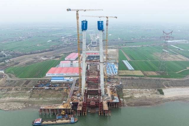 (251224) -- JINGZHOU, Dec. 24, 2025 (Xinhua) -- An aerial drone photo taken on Dec. 24, 2025 shows the south tower construction site of Libu Yangtze River road-rail bridge project in Jingzhou, central China's Hubei Province. With a main span of 1,120 meters, the Libu Yangtze River road-rail bridge will further improve traffic network of the Yangtze River Economic Belt after completion. (Xinhua/Wu Zhizun)