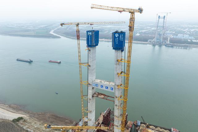 (251224) -- JINGZHOU, Dec. 24, 2025 (Xinhua) -- An aerial drone photo taken on Dec. 24, 2025 shows the south tower construction site of Libu Yangtze River road-rail bridge project in Jingzhou, central China's Hubei Province. With a main span of 1,120 meters, the Libu Yangtze River road-rail bridge will further improve traffic network of the Yangtze River Economic Belt after completion. (Xinhua/Wu Zhizun)