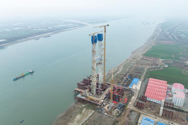 (251224) -- JINGZHOU, Dec. 24, 2025 (Xinhua) -- An aerial drone photo taken on Dec. 24, 2025 shows the south tower construction site of Libu Yangtze River road-rail bridge project in Jingzhou, central China's Hubei Province. With a main span of 1,120 meters, the Libu Yangtze River road-rail bridge will further improve traffic network of the Yangtze River Economic Belt after completion. (Xinhua/Wu Zhizun)