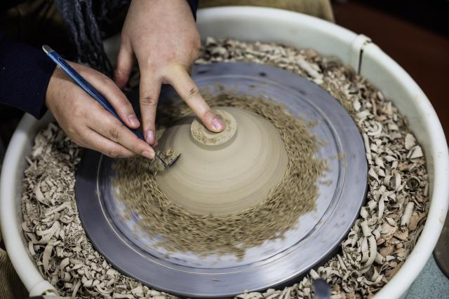 (251224) -- CIXI, Dec. 24, 2025 (Xinhua) -- A craftwoman makes a porcelain work at a porcelain workshop in an art village in Kuangyan Town, Cixi City, east China's Zhejiang Province, Dec. 24, 2025. In recent years, Kuangyan Town has built an art village integrated with cultural tourism to develop local rural industries and promote rural revitalization. (Xinhua/Xu Yu)