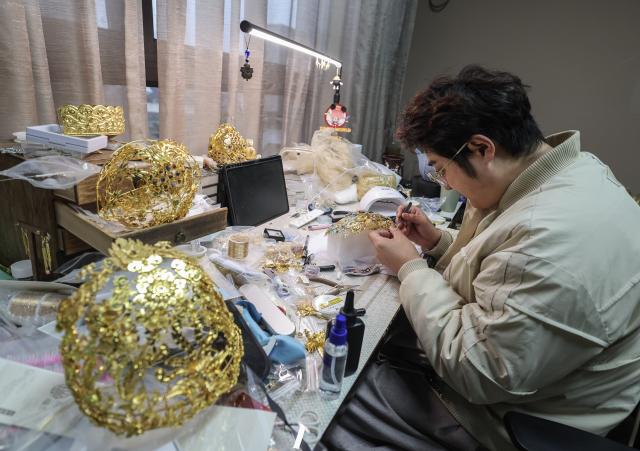 (251224) -- CIXI, Dec. 24, 2025 (Xinhua) -- A craftsman makes a handicraft in an art village in Kuangyan Town, Cixi City, east China's Zhejiang Province, Dec. 24, 2025. In recent years, Kuangyan Town has built an art village integrated with cultural tourism to develop local rural industries and promote rural revitalization. (Xinhua/Xu Yu)