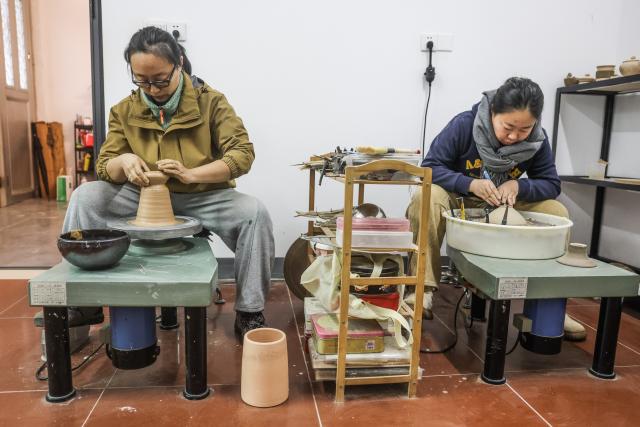 (251224) -- CIXI, Dec. 24, 2025 (Xinhua) -- Craftswomen make porcelains at a porcelain workshop in an art village in Kuangyan Town, Cixi City, east China's Zhejiang Province, Dec. 24, 2025. In recent years, Kuangyan Town has built an art village integrated with cultural tourism to develop local rural industries and promote rural revitalization. (Xinhua/Xu Yu)