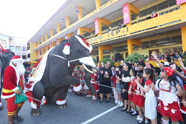 (251224) -- AYUTTHAYA, Dec. 24, 2025 (Xinhua) -- An elephant in Christmas-themed costumes interacts with students during a Christmas celebration at a school in Ayutthaya, Thailand, Dec. 24, 2025. (Xinhua/Rachen Sageamsak)