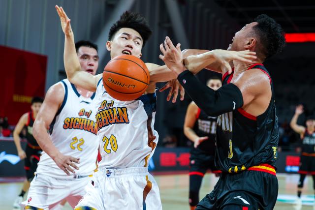 (251225) -- BEIJING, Dec. 25, 2025 (Xinhua) -- Zhang Gaoming (L) of Sichuan Blue Whales defends He Xining of Shenzhen Leopards during the 6th round match at the 2025-2026 season of the Chinese Basketball Association (CBA) league in Shenzhen, south China's Guangdong Province on Dec. 24, 2025. (Photo by Peng Zhigang/Xinhua)