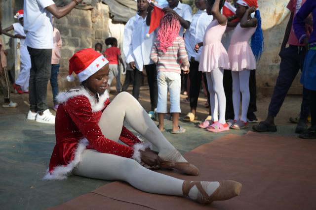 (251225) -- NAIROBI, Dec. 25, 2025 (Xinhua) -- A young dancer puts on her shoes on a simple stage at the Kibera slum in Nairobi, Kenya, Dec. 23, 2025. A Christmas ballet performance organized by the Kibera Ballet School was held here on Tuesday, attracting many local residents to watch. (Xinhua/Yang Guang)